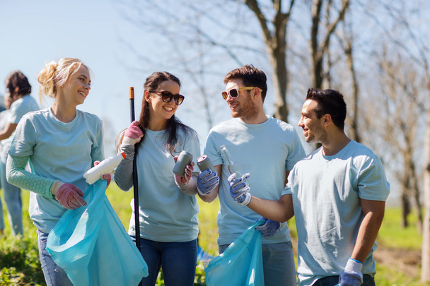 volunteers with garbage bags cleaning park area - Fotó, kép