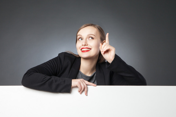 Mujer de negocios sonriente con el dedo en alto
 - Foto, imagen