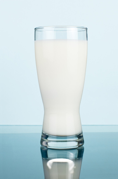 Glass of fresh milk on a dark cyan background - Fotoğraf, Görsel