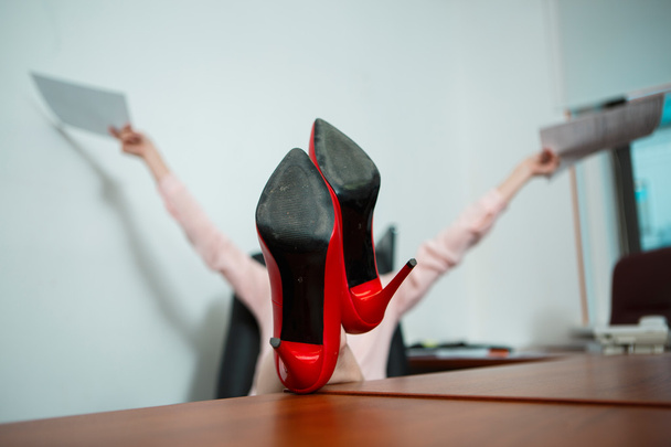 Entspannte Geschäftsfrau mit Beinen auf dem Schreibtisch - Foto, Bild