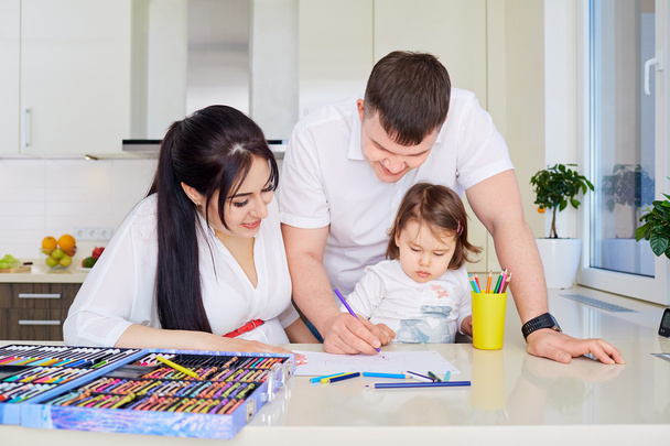 Smiling family drawing together in kitchen at home - Foto, Bild