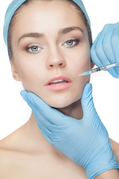 Attractive woman at plastic surgery with syringe in her face - Fotografie, Obrázek