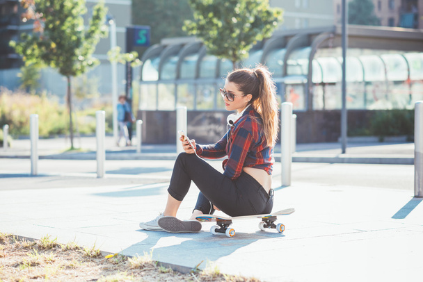 woman sitting on skateboard  - Foto, afbeelding