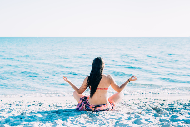 Donna che fa yoga in spiaggia - Foto, immagini
