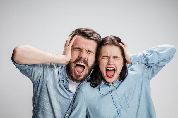 Close up photo of angry man and woman touching their heads - Foto, afbeelding
