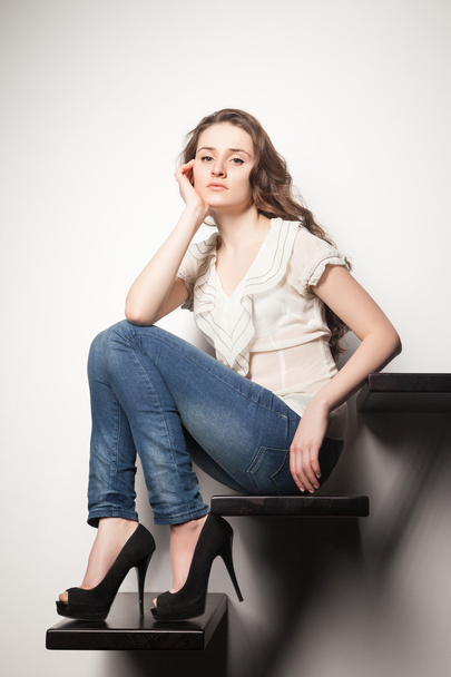 Portrait of brunette sitting on steps in wall - Fotografie, Obrázek