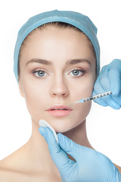 Attractive woman at plastic surgery with syringe in her face - Photo, Image