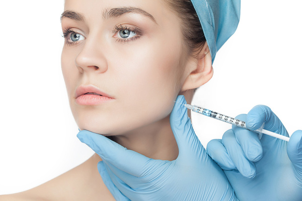 Attractive woman at plastic surgery with syringe in her face - Photo, image