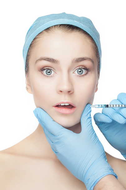 Привлекательная женщина в пластической хирургии со шприцем на лице
 - Фото, изображение