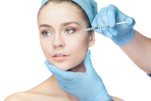 Attractive woman at plastic surgery with syringe in her face - Zdjęcie, obraz