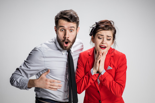 The surprised business man and woman on a gray background - Foto, immagini