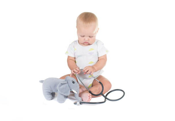 Adorable child dressed as doctor playing with toy Isolated on white background - Foto, immagini