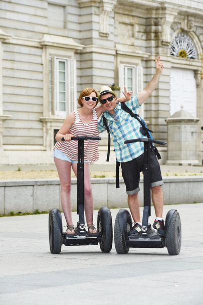 young happy tourist couple riding segway enjoying city tour in Madrid palace in Spain having fun driving together  - Foto, afbeelding