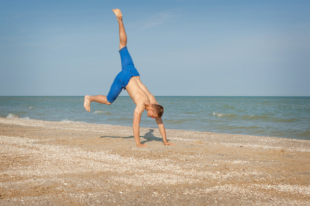 Young man jumping on beach - Фото, зображення