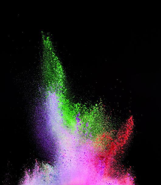Explosion of colored powder on black background - 写真・画像