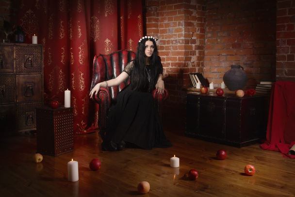 Beautiful witch in a black in the dark gothic interior - Photo, Image