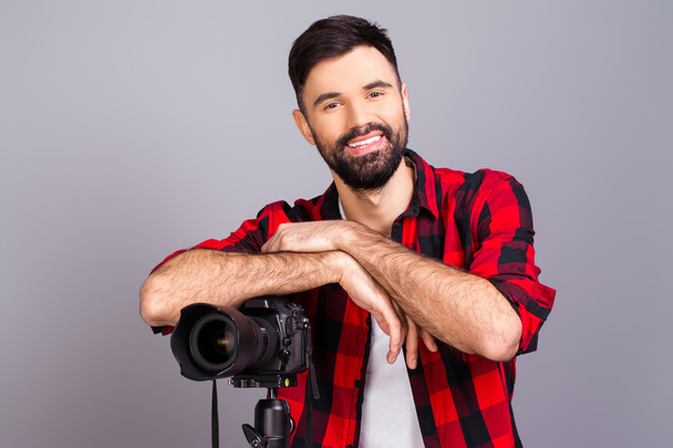 Iloinen onnellinen nuori mies seisoo kameran kanssa studiossa
 - Valokuva, kuva