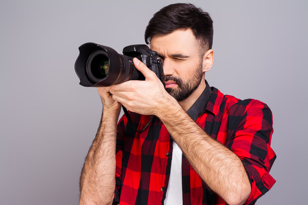 Handsome young man photographing you on gray background - Zdjęcie, obraz