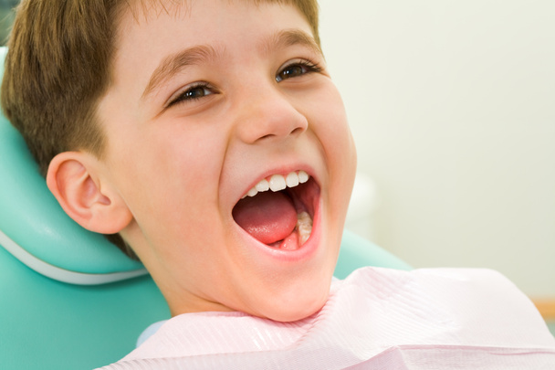 Youngster mit weit aufgerissenem Mund bei der Untersuchung beim Zahnarzt - Foto, Bild