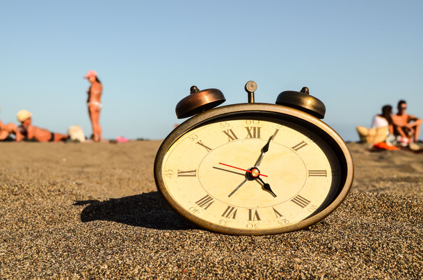 Relógio na praia de areia
 - Foto, Imagem