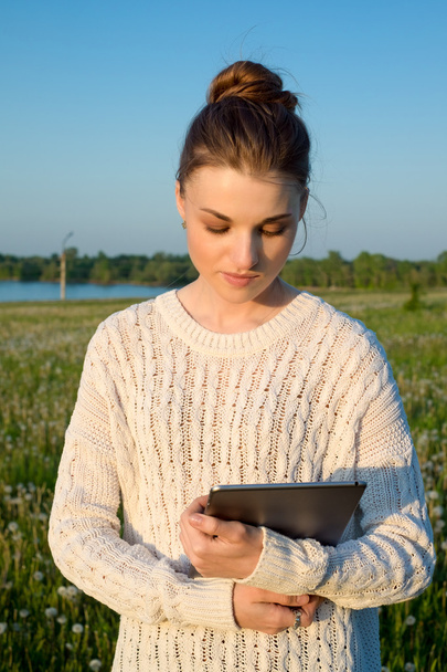 Girl standing and holding a tablet computer - Foto, immagini