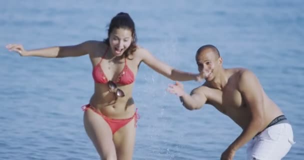 couple splashing at the beach - 映像、動画