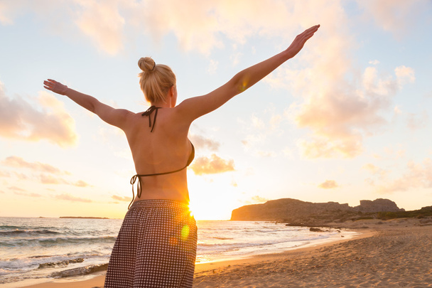 Szczęśliwa kobieta wolna, zachód słońca na piaszczystej plaży - Zdjęcie, obraz