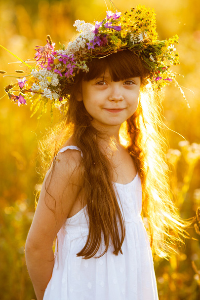Happy cute girl wearing a wreath of flowers - Fotoğraf, Görsel