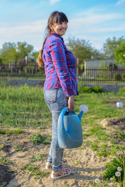 Smiling happy woman holding a watering can - Photo, Image