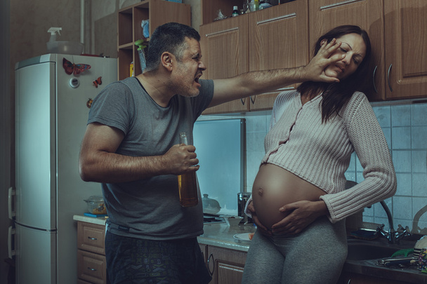Пьяный мужчина бьет беременную женщину.
. - Фото, изображение