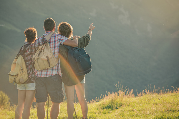 Three friends stand looking at panorama on mountain - Foto, Imagem
