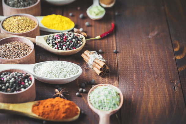 Colorful spices in wooden spoons - 写真・画像
