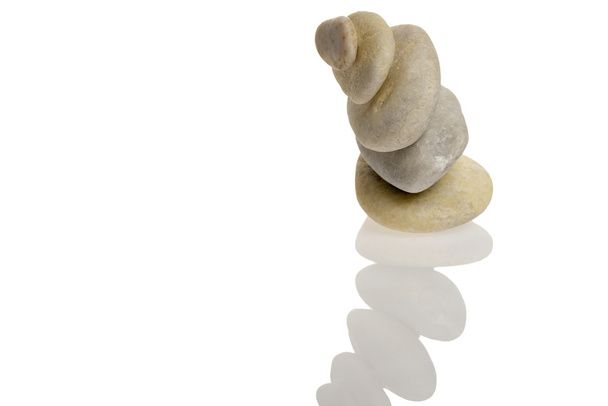 Cinco pedras em equilíbrio com reflexão em fundo branco
 - Foto, Imagem