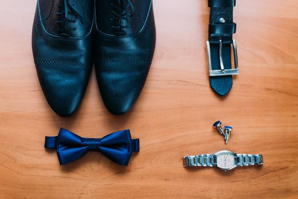 Close up of modern man accessories. Dark blue bowtie, leather shoes, belt, watch and cufflinks isolated on wood rustic background - Φωτογραφία, εικόνα