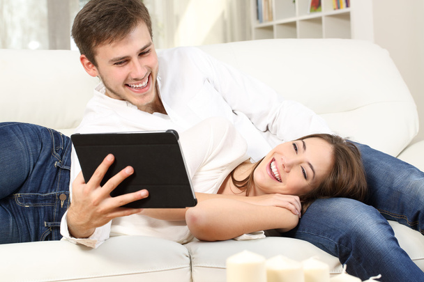 Ευτυχισμένο ζευγάρι παρακολουθούν μέσα σε έναν καναπέ - Φωτογραφία, εικόνα