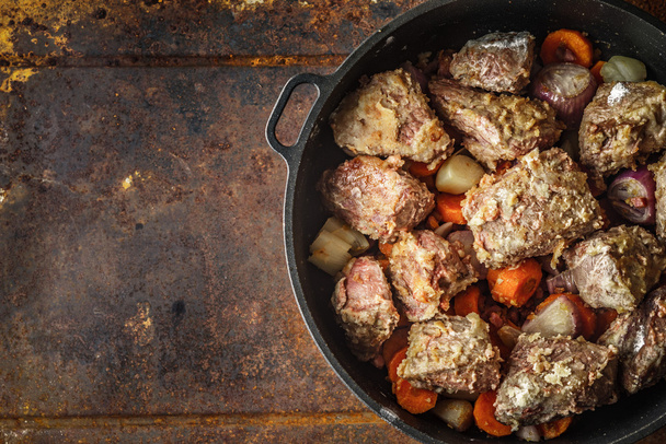 Meat with vegetables in the pan on the metal background - Foto, Bild