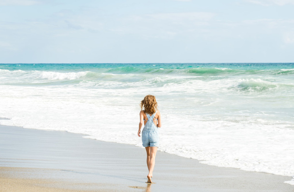 Young woman walking to the sea - Φωτογραφία, εικόνα