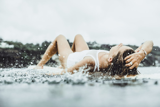 beautiful girl in the ocean Surf in the rain - Photo, Image