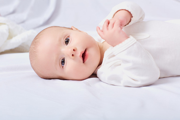 Baby girl on the white bed. - Photo, Image