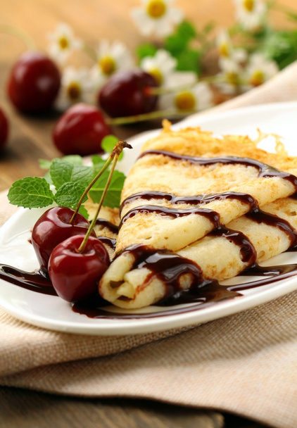 Sweet pancake with chocolate sauce and cherries - Foto, afbeelding