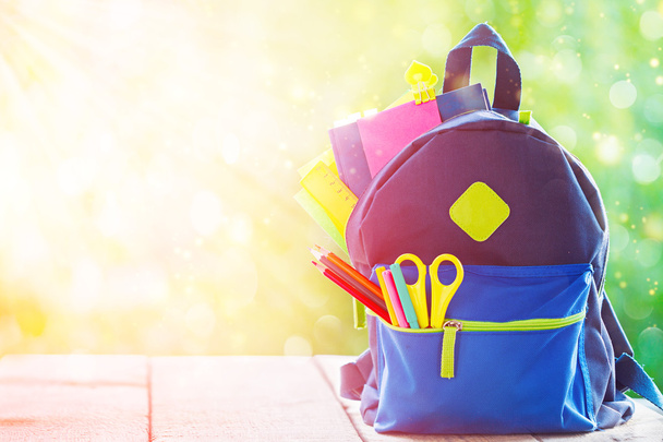 Full School backpack on wooden and nature background. - Foto, imagen