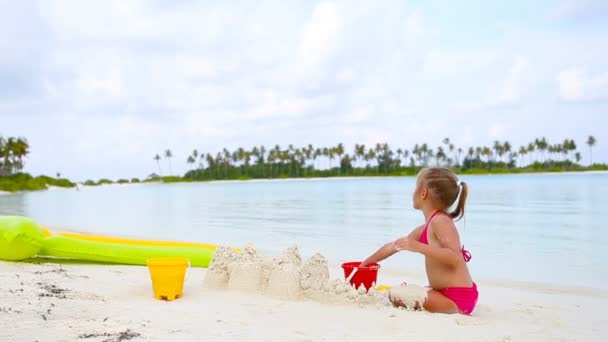 malá holčička v tropické dovolené hraje s hračkami, pláž - Záběry, video