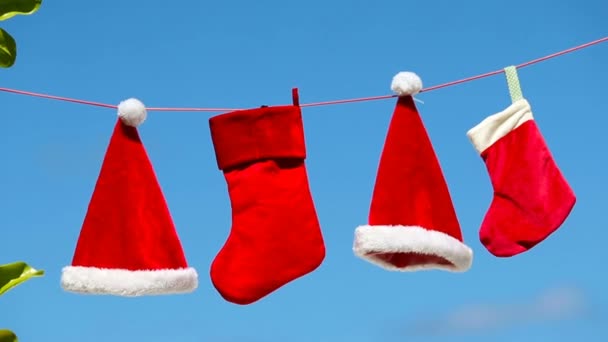 Κόκκινο Santa καπέλα και γυναικείων καλτσών Χριστουγέννων κρέμονται σε τροπική παραλία - Πλάνα, βίντεο