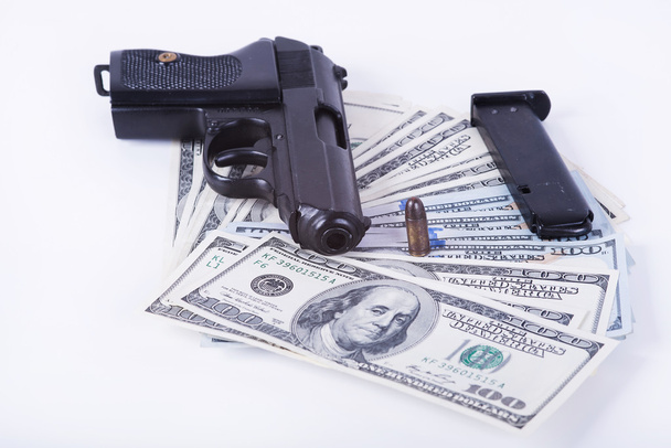 pistool met kogel op ons dollar bankbiljetten. - Foto, afbeelding