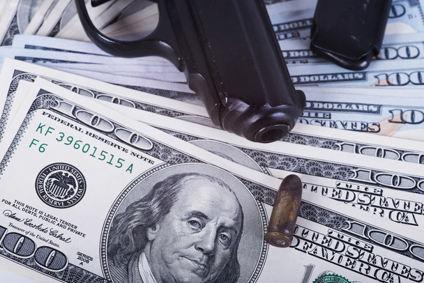 arme à feu avec balle sur les billets en dollars américains
. - Photo, image