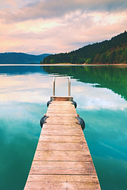 Talpa vuota in legno sul lago azzurro delle Alpi, pontile per barche a noleggio
 - Foto, immagini
