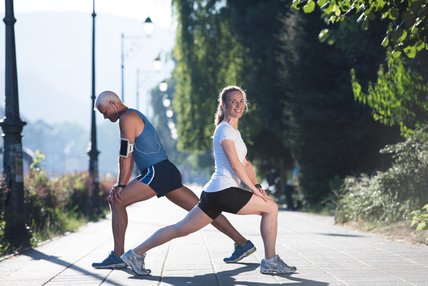 couple warming up and stretching before jogging - Фото, зображення