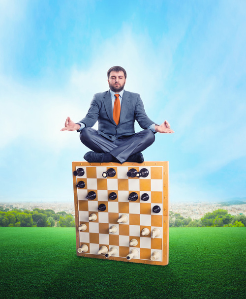 Empresario meditando en el tablero de ajedrez
 - Foto, imagen