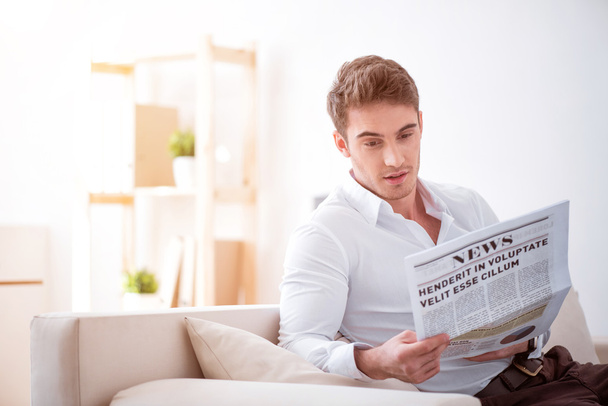 Pleasant delighted man reading newspaper - Zdjęcie, obraz