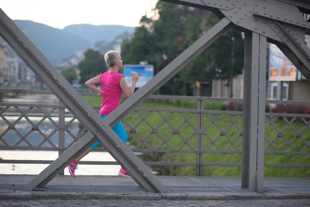 sporty woman running  on sidewalk - Photo, image